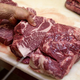 Person cuts into slab of raw steak